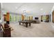 Spacious basement with a pool table, bar, seating, and natural light from multiple windows at 12980 Overlook Pass, Roswell, GA 30075