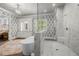 Modern bathroom boasts a soaking tub, glass shower, and vanity with beautiful fixtures and leaf-patterned wallpaper at 12980 Overlook Pass, Roswell, GA 30075