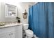 Bathroom with white vanity, vintage-style lighting, and decorative shower curtain at 12980 Overlook Pass, Roswell, GA 30075