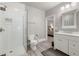 Bathroom with a glass shower, white cabinets, modern fixtures, and gray-patterned wallpaper at 12980 Overlook Pass, Roswell, GA 30075