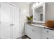 Bathroom featuring a white vanity with marble countertop, decorative mirror, and plentiful storage at 12980 Overlook Pass, Roswell, GA 30075