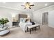 Bright bedroom with a tufted headboard, ceiling fan, bench, bedside tables and lamps at 12980 Overlook Pass, Roswell, GA 30075