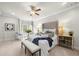 Bright bedroom with a tufted headboard, ceiling fan, and sitting area by the windows for a relaxing space at 12980 Overlook Pass, Roswell, GA 30075