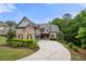 Stunning brick home with a concrete driveway and well-manicured lawn at 12980 Overlook Pass, Roswell, GA 30075