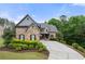 Charming brick and stone home with a well-manicured front lawn and a long driveway at 12980 Overlook Pass, Roswell, GA 30075