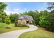 Beautiful home with brick and stone accents, lush landscaping, and a long driveway, nestled among mature trees at 12980 Overlook Pass, Roswell, GA 30075