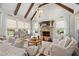 Cozy living room with a stone fireplace, beamed ceiling, and comfortable seating at 12980 Overlook Pass, Roswell, GA 30075