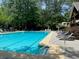 Community pool surrounded by lounge chairs and greenery to enjoy time outdoors at 12980 Overlook Pass, Roswell, GA 30075
