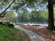 Community tennis court surrounded by greenery and a sidewalk at 12980 Overlook Pass, Roswell, GA 30075