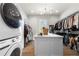 Spacious walk-in closet with a white center island, wood floors, and ample storage for clothes and shoes at 12980 Overlook Pass, Roswell, GA 30075