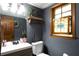 Charming bathroom featuring dark gray walls, updated fixtures, and a stained glass window adding to the home's character at 1429 Smithson Dr, Lithonia, GA 30058