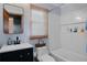 Bathroom with white tile tub, toilet, and vanity with dark cabinet at 1429 Smithson Dr, Lithonia, GA 30058