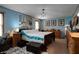 Spacious bedroom featuring a bed, a ceiling fan, three framed pictures and an ottoman at 1429 Smithson Dr, Lithonia, GA 30058