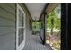 Inviting covered porch with wooden flooring, rocking chair, and scenic views of the surrounding greenery at 1429 Smithson Dr, Lithonia, GA 30058