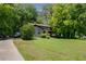Two-story house with green lawn, mature trees, and a private driveway in a wooded setting at 1429 Smithson Dr, Lithonia, GA 30058