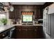 Kitchen with dark cabinetry, stainless steel appliances, granite countertops, and a window view providing a well-equipped area at 1429 Smithson Dr, Lithonia, GA 30058