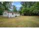 A spacious backyard behind a white-sided home surrounded by mature trees at 3952 Leisure Se Ct, Conyers, GA 30013