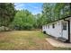 Expansive backyard featuring a white-sided home with a door and lush greenery providing a private outdoor space at 3952 Leisure Se Ct, Conyers, GA 30013