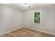 An empty bedroom featuring wood-look floors and a window with a view of the trees outside at 3952 Leisure Se Ct, Conyers, GA 30013