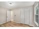 Bedroom with laminate floors, neutral walls and view to a closet and another room via white doors at 3952 Leisure Se Ct, Conyers, GA 30013