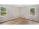Bedroom with laminate floors, neutral walls and two double-hung windows overlooking the side and back yards at 3952 Leisure Se Ct, Conyers, GA 30013