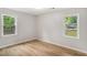 An empty bedroom with two windows that give views of the fenced backyard at 3952 Leisure Se Ct, Conyers, GA 30013