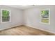 Bedroom with laminate floors, neutral walls and two double-hung windows overlooking the front and side yards at 3952 Leisure Se Ct, Conyers, GA 30013
