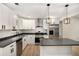 Stylish kitchen featuring white cabinets, stainless steel appliances, and gray countertops at 3952 Leisure Se Ct, Conyers, GA 30013