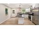 Beautiful kitchen with white cabinets, stainless steel appliances, kitchen island, and wood-look floors at 3952 Leisure Se Ct, Conyers, GA 30013