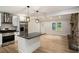 Open-concept kitchen with stainless steel appliances, white cabinets, island, and view to the fireplace at 3952 Leisure Se Ct, Conyers, GA 30013