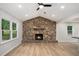 Inviting living room featuring a stone fireplace, hardwood floors, recessed lighting, and large windows at 3952 Leisure Se Ct, Conyers, GA 30013