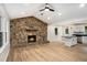 Open-concept living room with a stone fireplace, and seamlessly connects to a modern kitchen with a central island at 3952 Leisure Se Ct, Conyers, GA 30013
