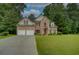 Beautiful two-story brick home with a well-manicured lawn, mature trees, and a convenient two-car garage at 4942 Brown Leaf Dr, Powder Springs, GA 30127