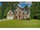 Charming two-story brick home with manicured lawn, lush landscaping, and a welcoming double door garage at 4942 Brown Leaf Dr, Powder Springs, GA 30127