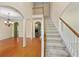 Bright foyer with staircase, chandelier, hardwood floors, and arched doorways offers a welcoming entrance at 4942 Brown Leaf Dr, Powder Springs, GA 30127