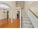Bright foyer featuring hardwood floors, staircase with white railing and open archways to living spaces at 4942 Brown Leaf Dr, Powder Springs, GA 30127