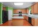 A spacious kitchen features wood floors, wooden cabinets, granite countertops and a center island at 4942 Brown Leaf Dr, Powder Springs, GA 30127
