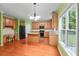 Open kitchen area with wood cabinets, an island, hardwood floors and plenty of natural light at 4942 Brown Leaf Dr, Powder Springs, GA 30127