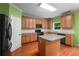 A spacious kitchen features wood floors, wooden cabinets, granite countertops and stainless steel appliances at 4942 Brown Leaf Dr, Powder Springs, GA 30127