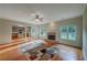Cozy living room boasts a brick fireplace, hardwood floors, ceiling fan and an open layout to the kitchen at 4942 Brown Leaf Dr, Powder Springs, GA 30127