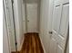 Hallway with hardwood floors features multiple doors and neutral-colored walls for a seamless design at 3988 Chimney Ridge Dr, Ellenwood, GA 30294