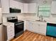 Bright kitchen featuring white cabinets, quartz countertops, an island, and modern stainless steel appliances at 3988 Chimney Ridge Dr, Ellenwood, GA 30294
