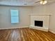 Bright living room featuring a white brick fireplace, hardwood floors, and natural light at 3988 Chimney Ridge Dr, Ellenwood, GA 30294