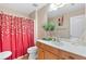 Bright bathroom featuring a vibrant shower curtain, neutral walls, and modern vanity with decorative plants at 988 Treymont Way, Lawrenceville, GA 30045