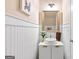Stylish powder room features wainscoting, a vessel sink, and gold mirror at 988 Treymont Way, Lawrenceville, GA 30045