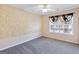 Carpeted bedroom with a ceiling fan, neutral walls and modern window treatments at 988 Treymont Way, Lawrenceville, GA 30045