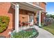 Inviting front porch with chairs, flowers, plants and brick facade at 988 Treymont Way, Lawrenceville, GA 30045