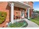 Cozy front porch with chairs, plants, and a decorative wreath, complemented by manicured landscaping at 988 Treymont Way, Lawrenceville, GA 30045