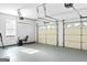 Spacious two car garage with natural light, exercise equipment, and automatic overhead doors at 988 Treymont Way, Lawrenceville, GA 30045