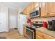 Galley kitchen has stainless steel appliances, wood cabinets, and light countertops at 988 Treymont Way, Lawrenceville, GA 30045